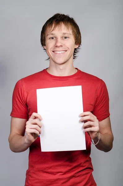 Hombre con camisa roja sonríe y muestra una tarjeta blanca Imágenes De Stock Sin Royalties Gratis