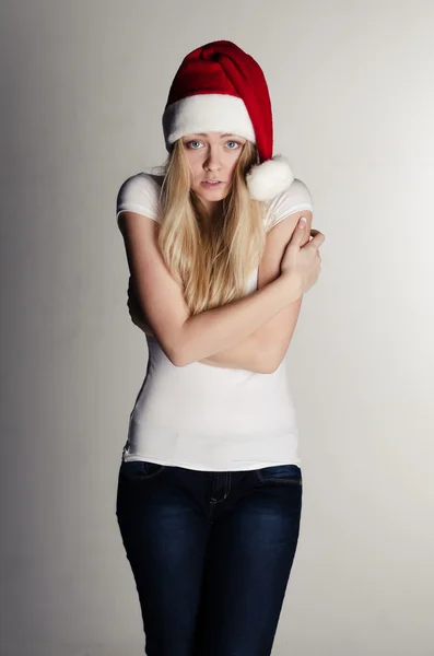 Young girl in a red santa hat frezing — Stock Photo, Image