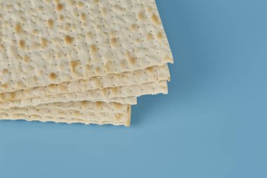 Fısıh bayramında dini matzah, mavi arka planda.