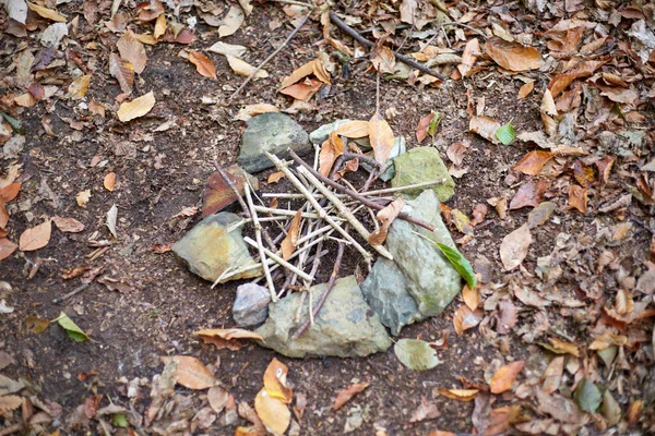 Préparation d'une place pour un feu de joie, pierres empilées autour des branches — Photo