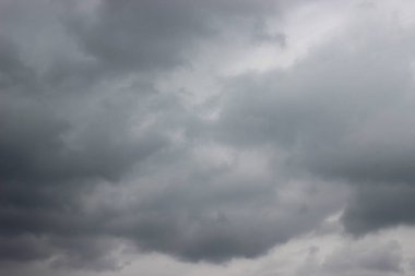 Bulutlu gökyüzü arkaplanı ve gri bulutlar. Yazın mavi gökyüzünde gri kabarık bulutlar