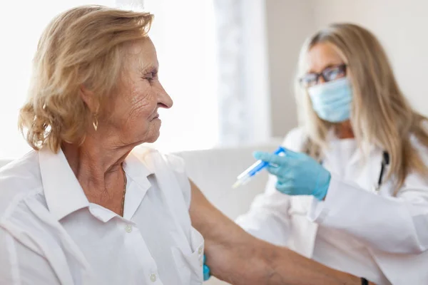 Doctor administering a vaccine on an elderly patient