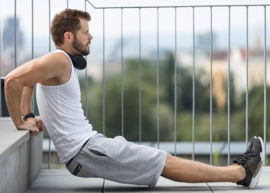 Yakışıklı genç adam antrenman yapıyor ve dışarıda çalışıyor.