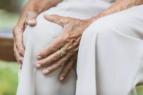 Senior Vrouw Zit Bank Houdt Haar Pijnlijke Knie Vast — Stockfoto