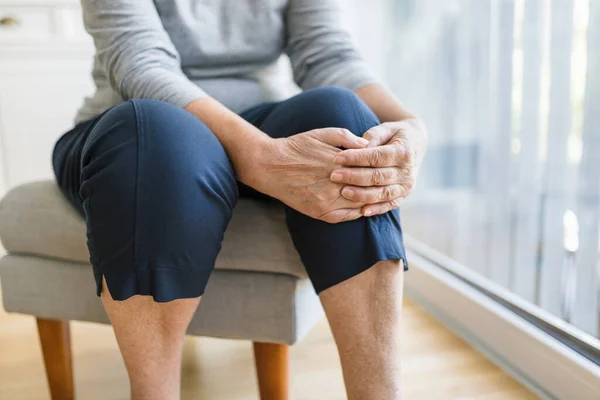 Oudere Vrouw Thuis Die Haar Pijnlijke Knie Vasthoudt — Stockfoto