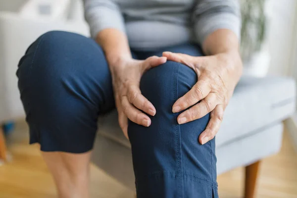 Senior Woman Sitting Bench Holding Her Painful Knee Стоковое Фото