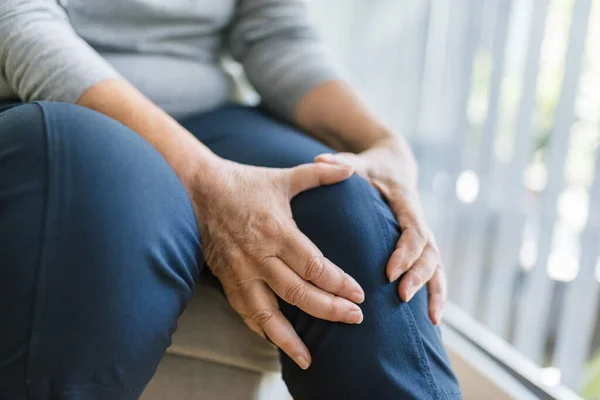 Senior Vrouw Zit Bank Houdt Haar Pijnlijke Knie Vast — Stockfoto