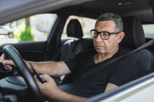 Active Senior His 70S Driving Car Usig His Mobile Phone — Zdjęcie stockowe