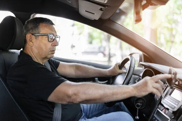 Senior Steering Wheel Using Navigation Looking Directions — стоковое фото
