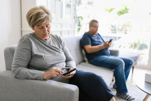 Oudere Echtpaar Zitten Bank Met Behulp Van Hun Mobiele Telefoons — Stockfoto