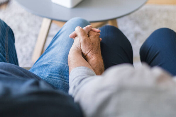 Happy romantic senior couple in love holding hands at home 