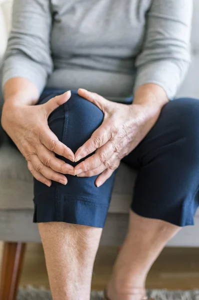 Seniorin Sitzt Auf Bank Und Hält Ihr Schmerzhaftes Knie — Stockfoto
