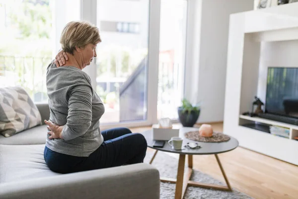 Oudere Vrouw Thuis Met Pijn Onderrug — Stockfoto