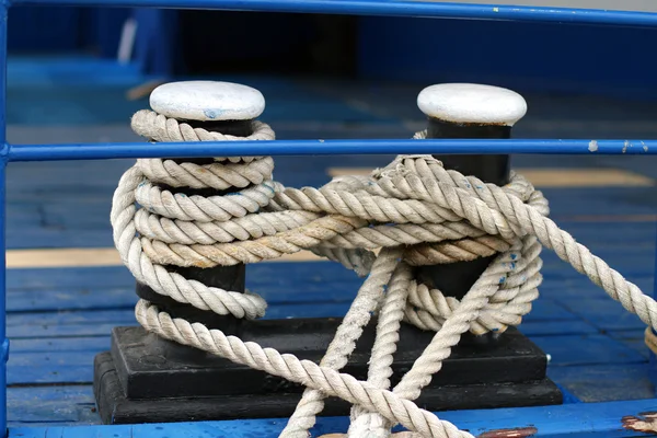 Close-up of a mooring rope with a knotted end tied around a clea — Stock Photo, Image
