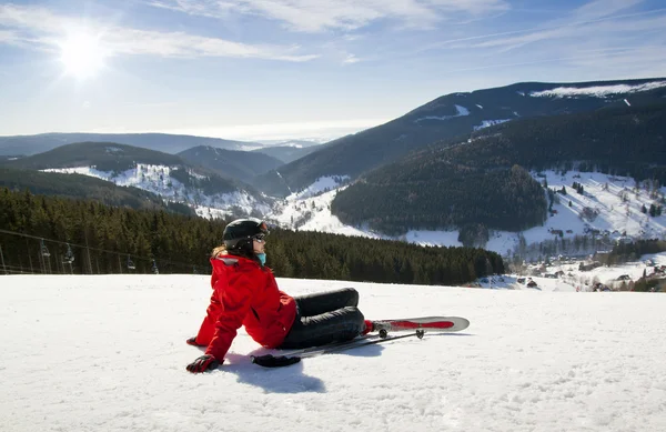 Mulher esquiadora deitada na neve, alta montanha — Fotografia de Stock