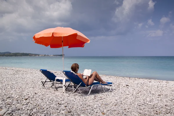 Sun longer and umbrella on empty sandy beach — Stock Photo, Image