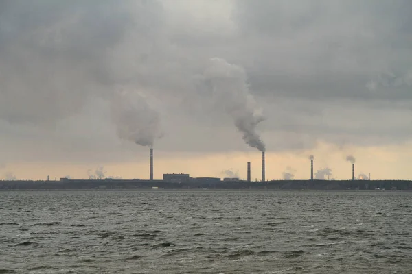 Lipetsk fabrikası suyun arka planında sigara içiyor.