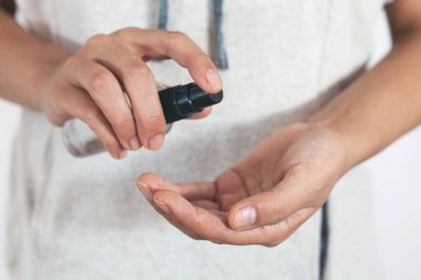 Kadın elleri antiseptik sprey kullanıyor. COVID-19 Salgın Coronavir. Bakterilerden ve virüsten koruma. Temiz eller, hijyen ve sağlık hizmetleri.