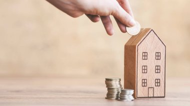 Birinin eli eve bozuk para, para biriktirme ya da emlak konsepti için yatırım yapma basamakları olan para kutusu koydu.