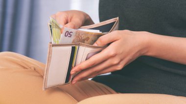 Para dolu sütlü kahverengi cüzdanı olan kız.