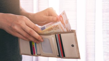 Para dolu sütlü kahverengi cüzdanı olan kız.