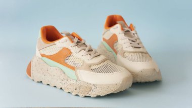 Mavi arka planda renkli ayakkabılar.