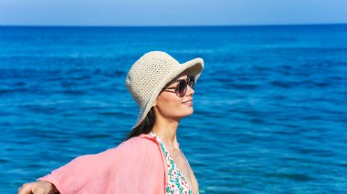 Sahildeki şapkalı kadın.