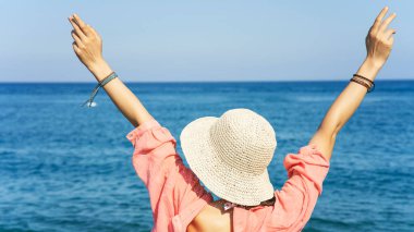 Sahildeki şapkalı kadın.