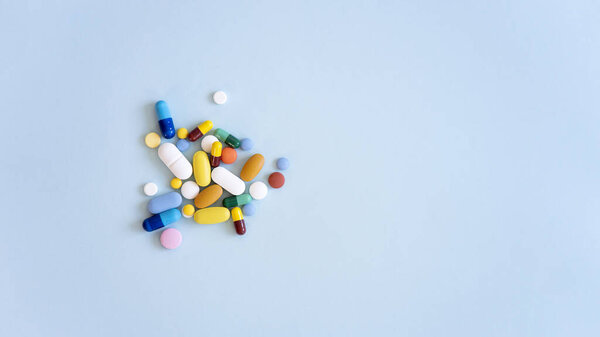 Ассорти лекарственных препаратов таблетки, таблетки и капсулы на синем фоне