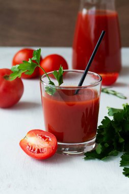 Domates suyu ve taze domates. Taze domates suyu, tuzlu ve maydanozlu. İçindekilerle birlikte Bloody Mary kokteyli. Beyaz arka planda izole edilmiş bir bardakta votka ve domates suyu ile alkollü içecek..