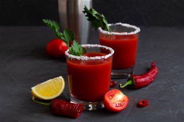 Biberli, baharatlı, tuzlu ve sarı limonlu taze domates suyu ve fotokopi alanı. Bloody Mary kokteyli. Votka, vampir kokteyli ve siyah arka plandaki malzemelerle alkollü içecek..