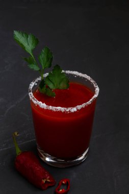 Biber, baharat, tuz ve buzlu domates suyu ve fotokopi alanı. Bloody Mary kokteyli. Alkollü votka, siyah arka planda vampir kokteyli. dikey.