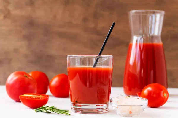 tomato juice and tomatoes.glass of Tomato juice with pink salt. Healthy drink with tomato juice in a glass isolated on a white background with copy space