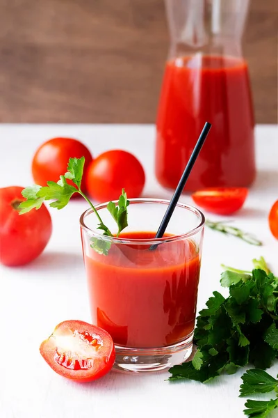 tomato juice and fresh tomatoes. Tomato juice with parsley. Bloody Mary cocktail with ingredients. Healthy drink with tomato juice in a glass isolated on a white background. copy space. vertical