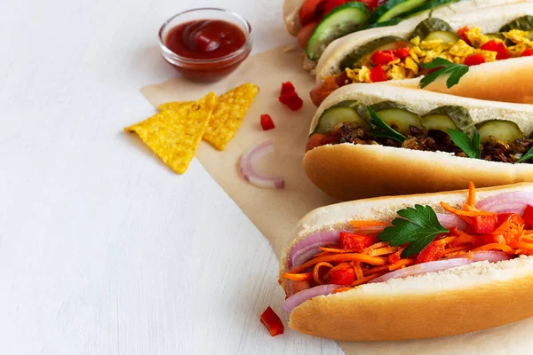 Ketçap ve hardallı sosisli sandviç. Farklı malzemeli sosisli sandviç: turşu, kızarmış soğan, domates ve havuç. Fast food konsepti.