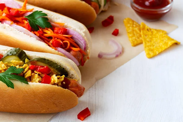 Yakın plan, domatesli, salatalıklı, soğanlı, salatalı, havuçlu, baharatlı ve hardallı farklı ev yapımı sosisli sandviç. Fast food konsepti