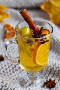 Yakın plan ekose kumaşlı ve fotokopi alanı olan bir içecek. Noel sıcak beyaz şarabı ballı bardakta, tarçınlı çubuklar ve ışık arka planında yıldız anason. Baharatlı sıcak içecek.