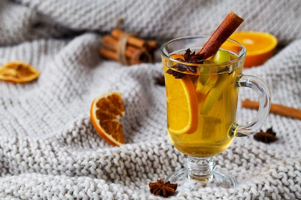 Bir bardak portakallı sıcak şarap. Kopya alanlı ekose örgü üzerinde sıcak bir içecek. Yılbaşı sıcak beyaz şarap bardakta bal, tarçın çubukları ve ışık arka planında yıldız anason..