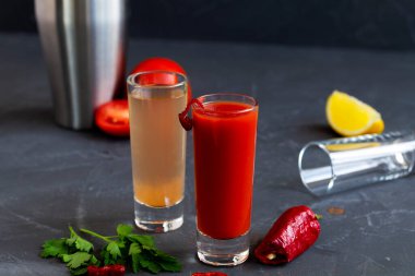 Siyah arka planda iki tekila shot. Sangrita, tekila, domates suyu, acı baharat, acı biber ve limonlu Meksika geleneksel alkol içkisidir. votka