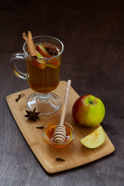 mulled wine with spices on the cutting board. apple cider with apple and honey. Hot fruit tea with spices: cinnamon, cardamon, anise on the wooden table. Christmas drinks.copy space. vertical