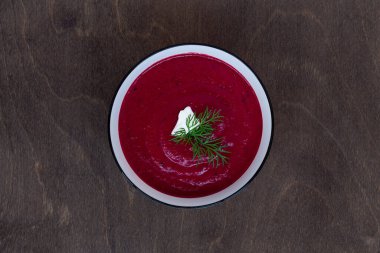 Sebzeli sebze çorbası. Kahverengi ahşap arka planda bir kase pancar kremalı çorba. Sağlıklı beslenme yemeği. Düz yerde, üst tarafta. Boşluğu kopyala