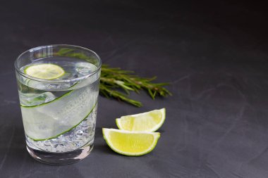 Siyah üzerine mojito kokteyli. Limonlu ve biberiyeli salatalık suyu. Siyah masada ev yapımı limonata bardağı. Detoks suyu. Kopya alanı olan soğuk yaz limonatası.