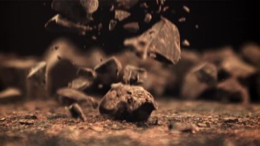 Süper yavaş çekimde düşen çikolata parçaları. Makro atış. 1000 fps hızla yüksek hızlı bir kamerayla çekildi..