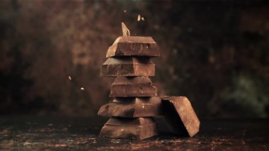 Süper yavaş çekimde çikolata dilimlerinin üzerine düşen acı, siyah çikolata parçaları..