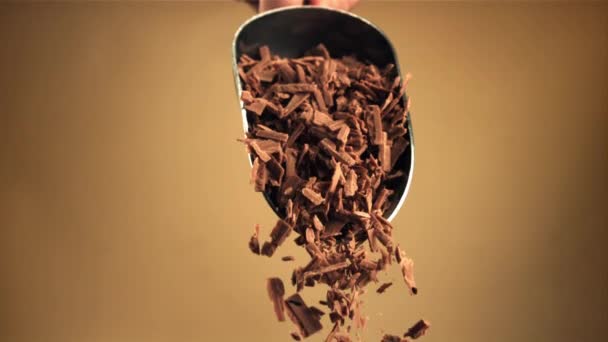 Super slow motion faller riven mjölkchoklad från en skopa. — Stockvideo