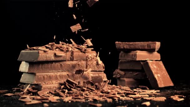 Super slow motion vallende stukjes melkchocolade. Gefilmd op een hoge snelheidscamera met 1000 fps. — Stockvideo