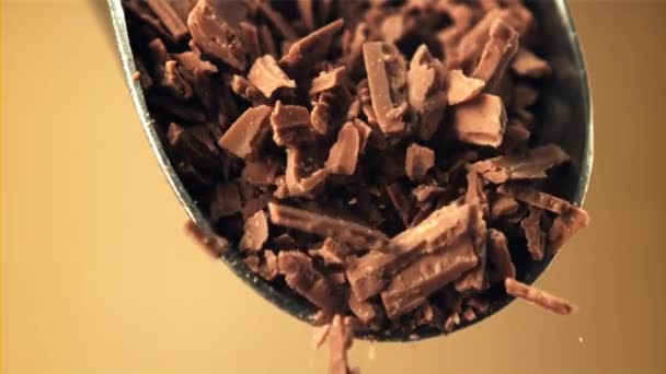 Super slow motion vallen van geraspte melkchocolade uit een primeur. — Stockvideo