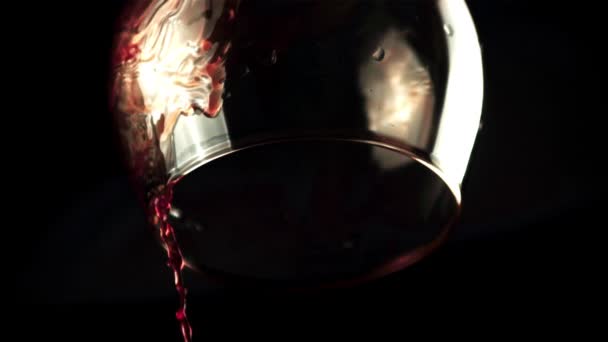 赤ワインを滴下ガラスからの超スローモーション。黒を背景に. — ストック動画