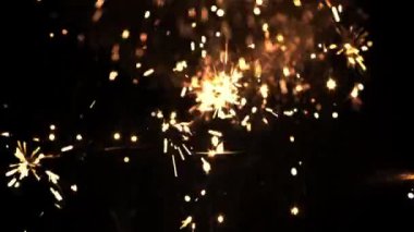 Siyah bir arka planda Yeni Yıl havai fişeklerinin parlak kıvılcımları.