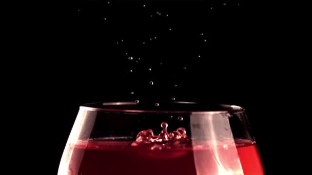 Super zpomalení kapka padá do sklenice vína s cákancemi. Natočeno na vysokorychlostní kameře rychlostí 1000 snímků za sekundu. — Stock video
